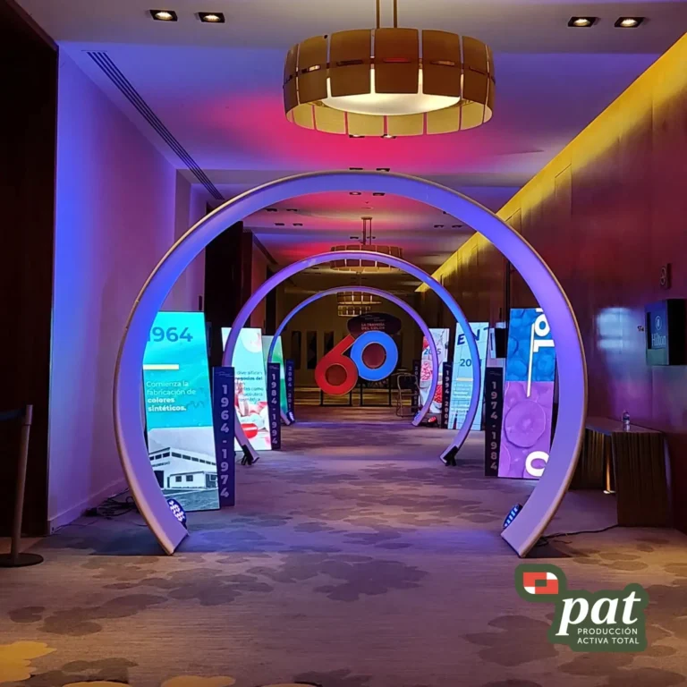 Vista interior de espacio para eventos corporativos con iluminación moderna, mesas de trabajo y pantallas informativas de PAT México.