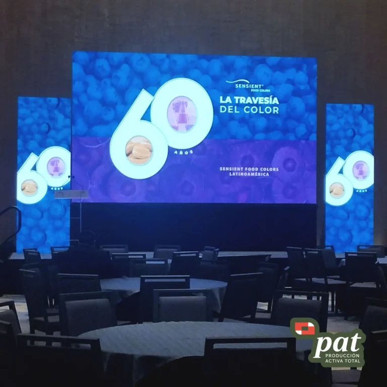 Espacio para eventos y capacitaciones con mesas de trabajo, sillas y pantalla de gran formato.